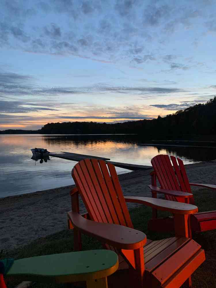 Two adirondack chairs at twilight on the beach